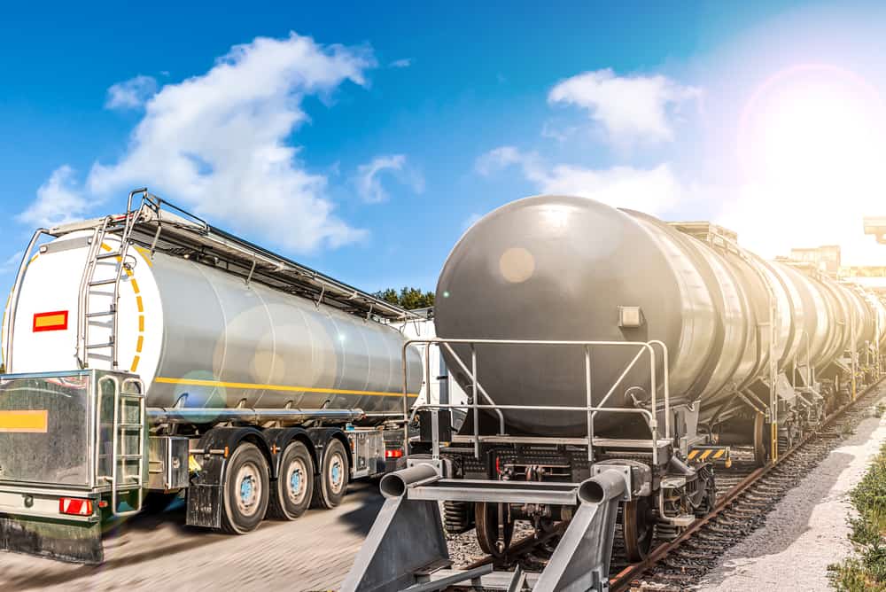 A row of large cylindrical rail tankers on a railway track, designed for transporting liquids such as fuel, oil, or chemicals.